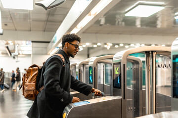 Young man using public transportation turnstile commuter travel