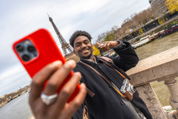 Traveller man smiling taking selfie with eiffel tower