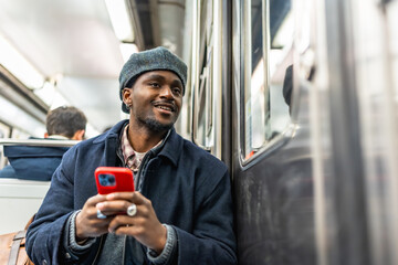 Young man traveling in subway using smartphone