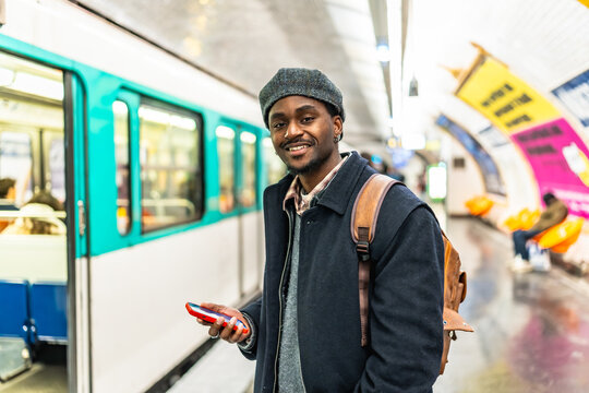 Young man smiling while waiting for subway train in paris