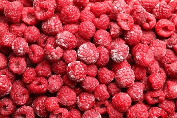 Frozen ripe raspberries as background, top view