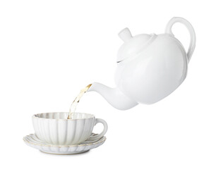Pouring hot tea into cup from teapot on white background