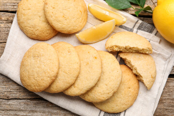 Tasty lemon cookies and fruit slices on wooden table, flat lay