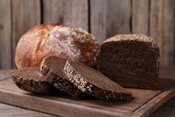 Different types of bread on wooden table, closeup