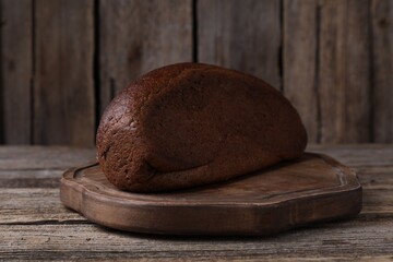 Delicious fresh rye bread loaf on wooden table, closeup