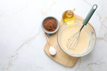 Different ingredients for dough and whisk on white marble, flat lay. Space for text