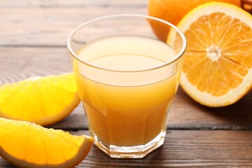 Fresh orange juice and fruits on wooden table, closeup