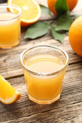 Fresh orange juice and fruits on wooden table, closeup