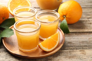 Fresh orange juice and fruits on wooden table, closeup