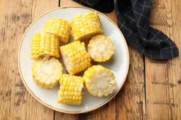 Pieces of boiled corn cobs on wooden table, top view