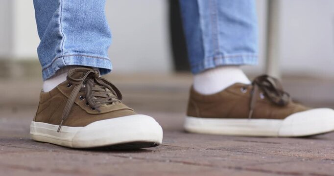 Weight shifting to left sneaker, right sneaker lifting rolling into planting on brick walkway