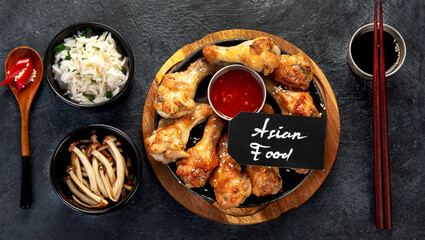 Baked chicken wings in asian style with sauces.