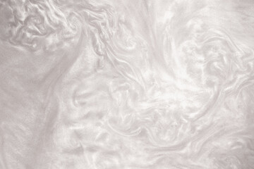 Shimmering silver abstract background. Liquid glitter paint texture waves and swirls. Beautiful shiny white glitter texture. Metallic silver paint close-up as a holiday background.