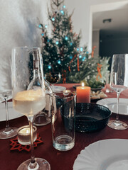 Table setting with Christmas decorations in living room. Setup for New Year celebration dinner. Table preparing for Christmas feast. High quality photo
