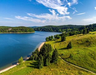 Serene lake surrounded by green hills and forests, blue sky