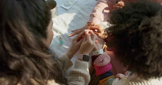 Client is extending hand, manicurist is wiping and applying mint polish for manicure on table