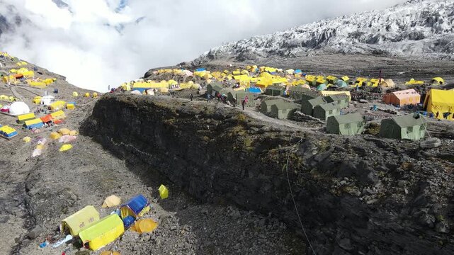Drone footage showcases Manaslu Base Camp below the 8,163m Himalayan peak. The scene reveals snowy ridges, rugged terrain, and the dramatic high-altitude environment of this remote mountain region.