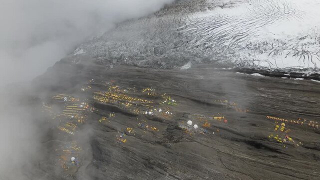 Drone footage showcases Manaslu Base Camp below the 8,163m Himalayan peak. The scene reveals snowy ridges, rugged terrain, and the dramatic high-altitude environment of this remote mountain region.