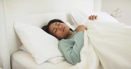 Fluttering eyelids waking Asian woman lifting head in bed and turning gaze right registering scene - Powered by Adobe