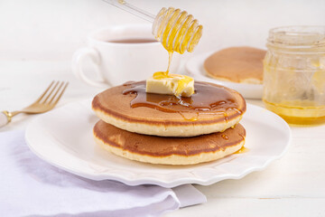 Pancakes with butter and honey or maple syrup drizzles