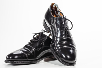 Closeup Image of Pair of Stylish Classic Formal Male Black Polished Oxford Leather Laced Shoes Placed Together Over White To Depict Footwear and Fashion Concepts.