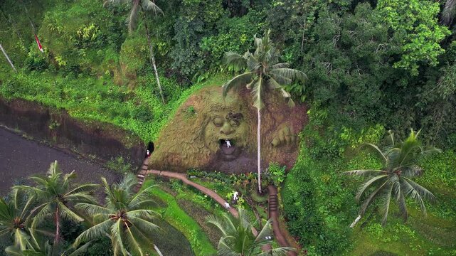 Aerial view of Alas Harum showing palm canopy trails, carved terraces, tropical park, hillside paths, and the monkey face mountain carving set within the Tegalalang jungle landscape.