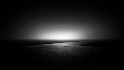 A dark monochrome landscape with a path leading towards a bright horizon