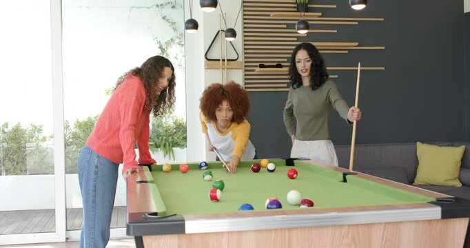 Spotting break diverse female friends breaking and watching balls scatter reacting at pool table