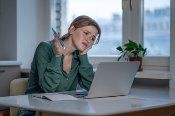 Overwhelmed woman ADHD struggling to focus while working or study on laptop at home. Deadline pressure, work stress, attention deficit, mental overload, distraction, anxiety and executive dysfunction.