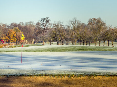 Frosty Golf Green with Flag on a Clear Winter Morning