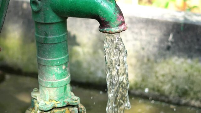 Drinking water at the hand pump on winter day in a india village. Ground water use for drinking.