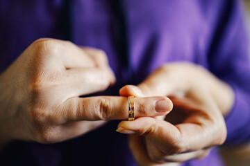 Person removing wedding ring symbolizing divorce and separation