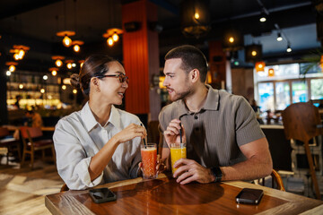 Diverse couple enjoying juice and conversation on a date