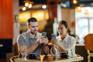 Couple distracted by cell phones in cafe