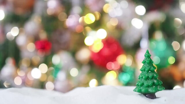 Close-up of tiny pine trees with Christmas light background