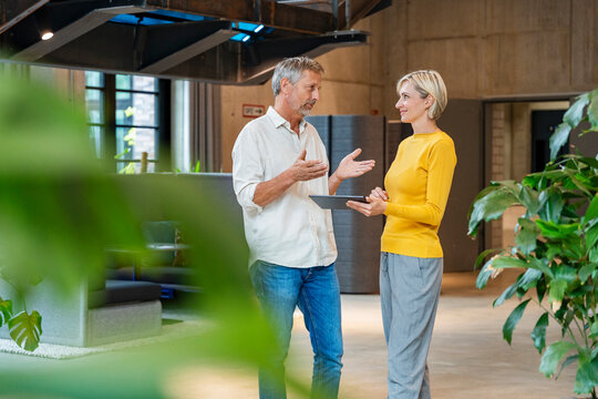 Business discussion in modern office with tablet and casual clothing