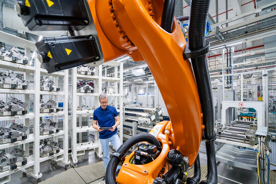 Engineer checking machinery with tablet in a modern industrial factory