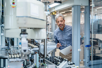 Engineer checking automation system with tablet in modern factory