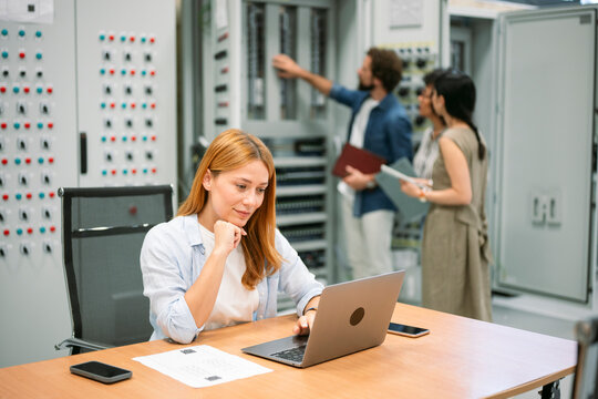Business team consulting in office with woman using laptop
