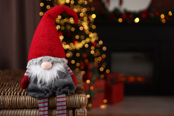 Fototapeta premium Funny Christmas gnome in decorated room, closeup. Space for text
