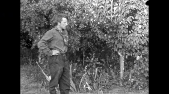 Working man came to help cultivate garden. Rural hard work. Young male woman digging soil. People working together in homegrown produce in summer. Old film. Archival retro 1960s. Vintage archive.