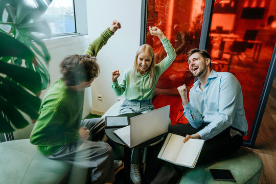 Business colleagues celebrating success together in modern office