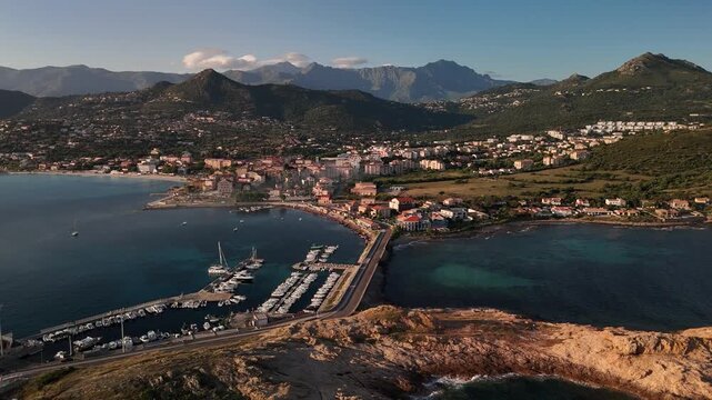 Expansive Aerial Drone Shot Over the Lush Green Mountains and Coastal Townscape of L'&Icirc;le-Rousse, Haute-Corse, Corsica, France.