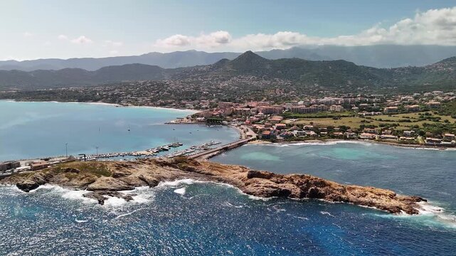 Aerial View of Boats Docked in the Marina next to the Rocky Pietra Peninsula in L'&Icirc;le-Rousse, Corsica, France.