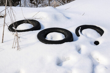 Old car tires in a snowdrift