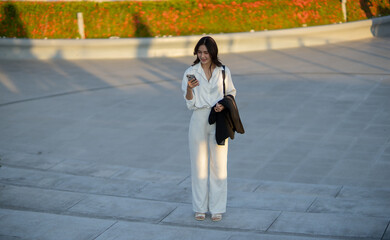Confident Asian businesswoman smiling in a modern corporate setting, attractive professional lady standing outdoors, showcasing success, beauty, career ambition, and cheerful lifestyle.