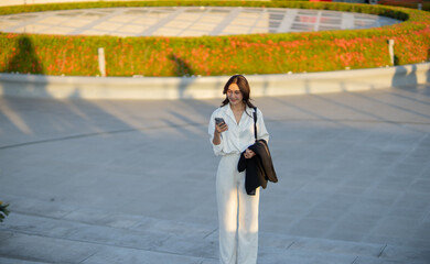 Confident Asian businesswoman smiling in a modern corporate setting, attractive professional lady standing outdoors, showcasing success, beauty, career ambition, and cheerful lifestyle.