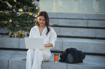 Confident Asian businesswoman smiling in a modern corporate setting, attractive professional lady standing outdoors, showcasing success, beauty, career ambition, and cheerful lifestyle.