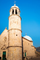 Fototapeta premium The bell tower of the church of our lady of the rocks in Perast at sunset. Bay of Kotor. UNESCO Natural and Culturo-Historical Region. Montenegro.