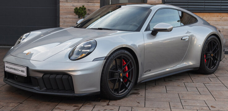 Slovenia, Ljubljana - 5 November 2025: Porsche 911 Carrera GTS parked in a stylish driveway during daylight.